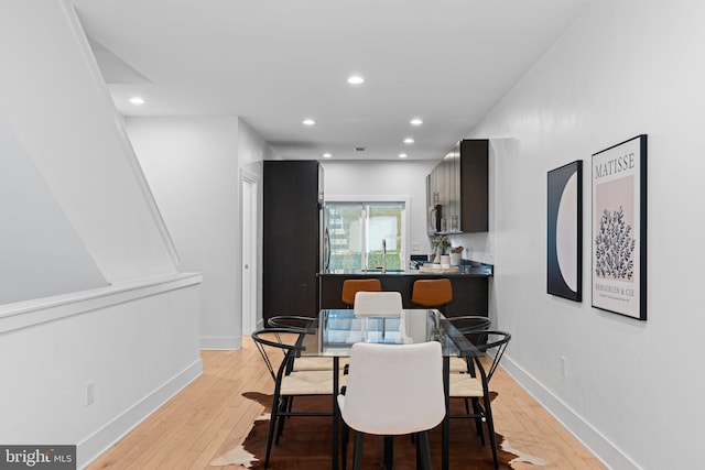 dining area with sink and light hardwood / wood-style flooring