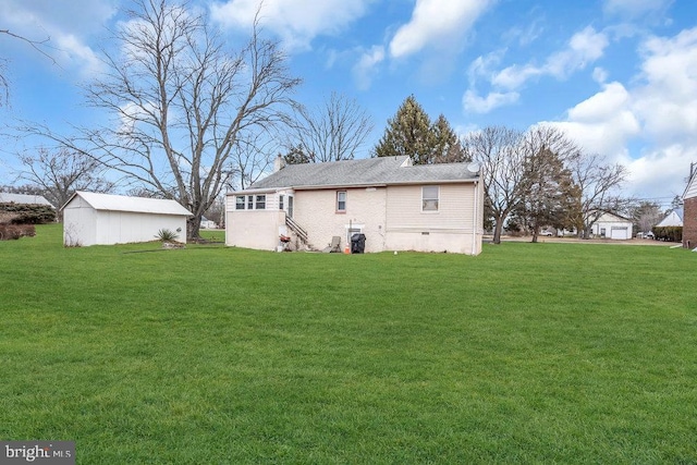 back of house featuring a lawn and a storage shed