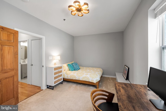 bedroom with light carpet and an inviting chandelier