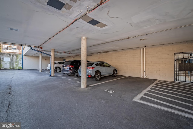 parking garage featuring concrete block wall and visible vents