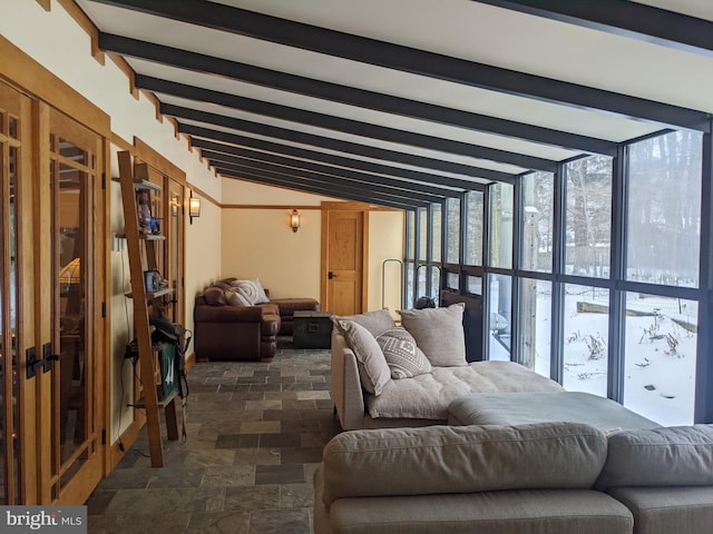 living room with a wall of windows and vaulted ceiling with beams