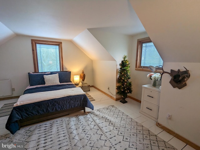 bedroom with multiple windows, radiator heating unit, and vaulted ceiling