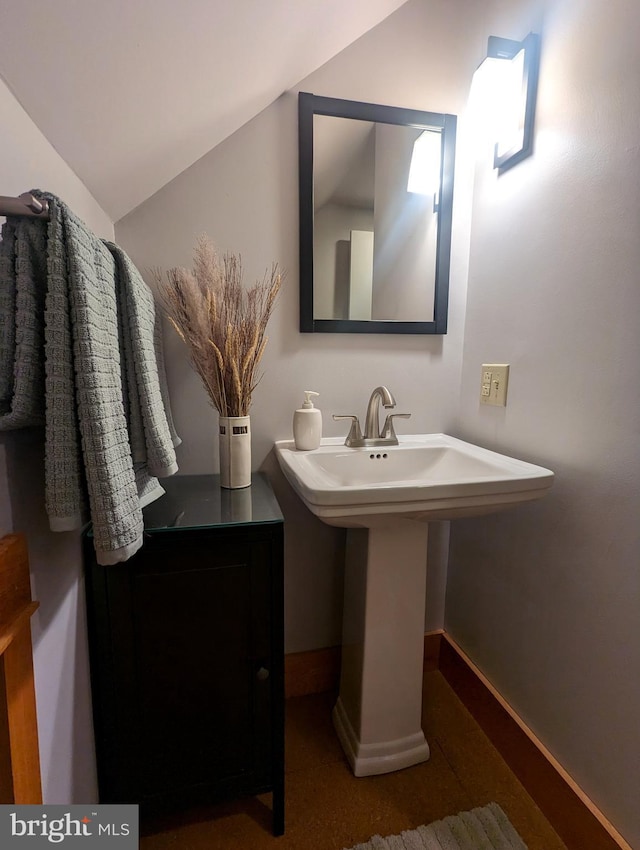 bathroom featuring vaulted ceiling and sink