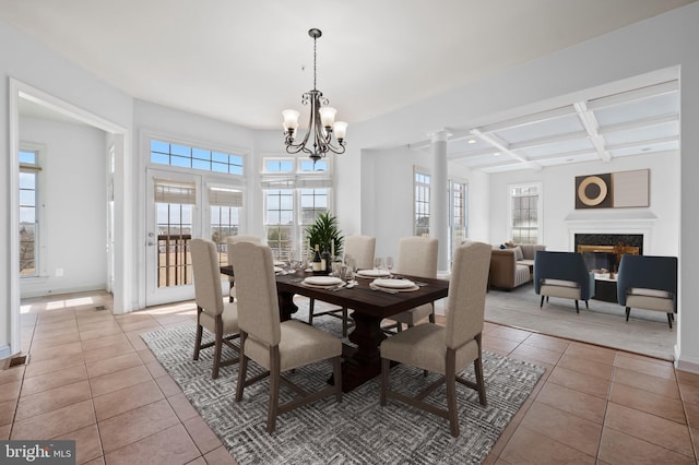 dining room with light tile patterned floors, baseboards, coffered ceiling, a notable chandelier, and a high end fireplace