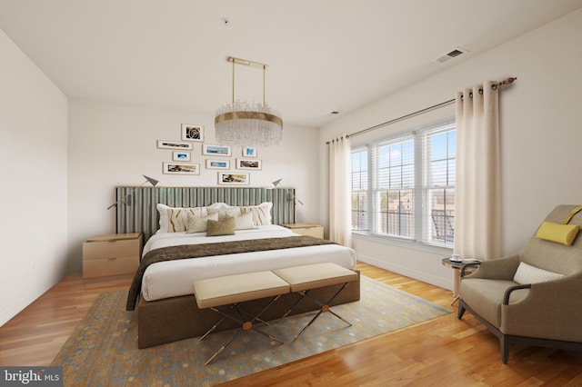 bedroom featuring a chandelier, wood finished floors, visible vents, and baseboards