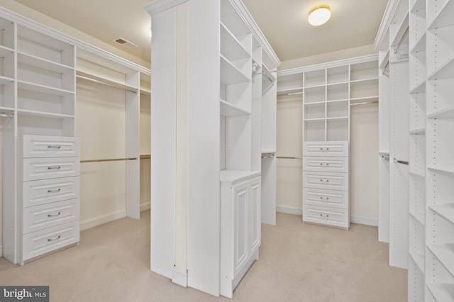 walk in closet featuring light colored carpet and visible vents