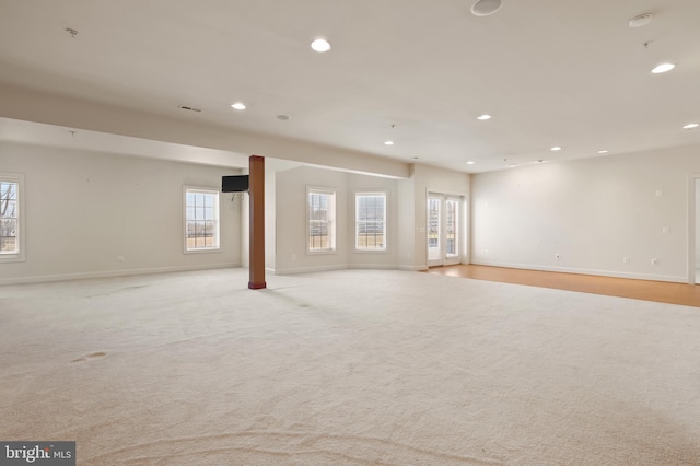 spare room featuring light carpet, baseboards, a wealth of natural light, and recessed lighting