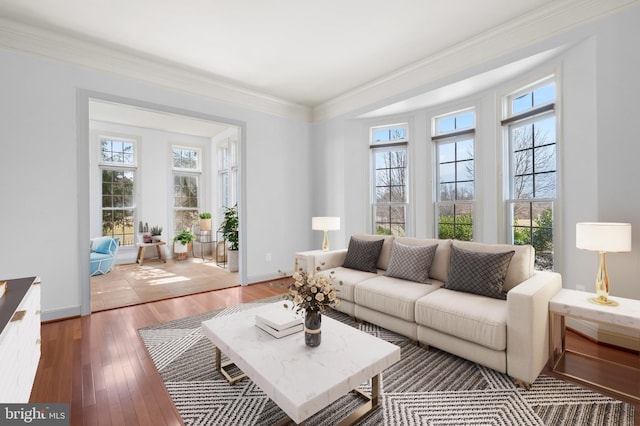 living area with crown molding, light wood-style flooring, and baseboards