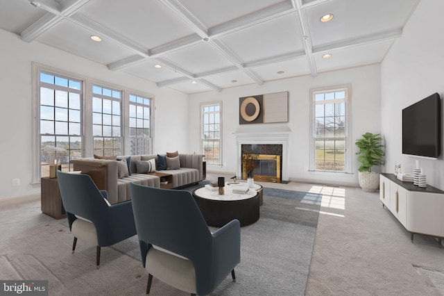 living room with plenty of natural light, a premium fireplace, coffered ceiling, and carpet flooring