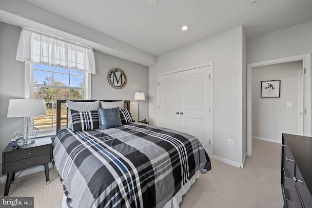 bedroom featuring light colored carpet and a closet