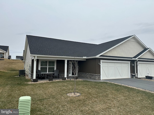 view of front of house featuring a garage, central AC, and a front yard