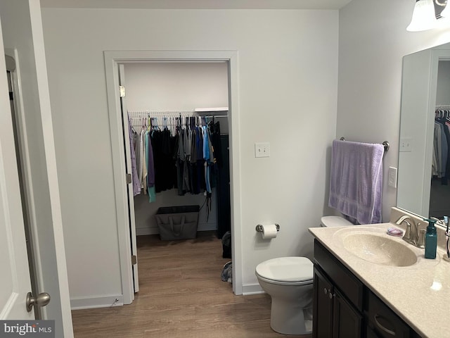 bathroom with wood-type flooring, vanity, and toilet