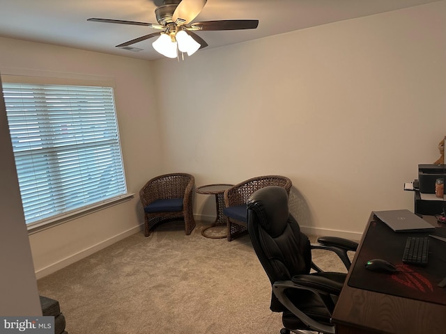 carpeted home office featuring ceiling fan