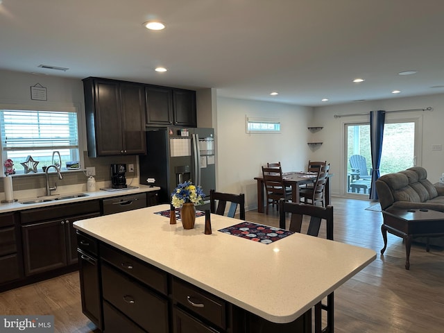 kitchen with stainless steel refrigerator with ice dispenser, wood-type flooring, a center island, and sink