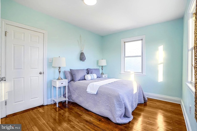 bedroom featuring dark wood finished floors and baseboards