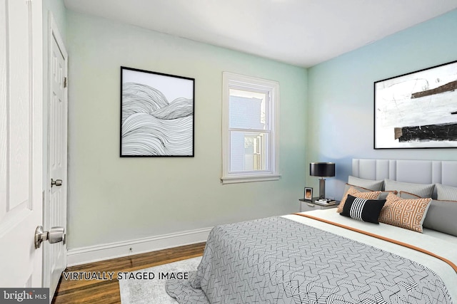 bedroom featuring baseboards and wood finished floors