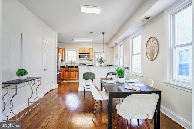 dining area featuring dark wood finished floors, visible vents, and baseboards