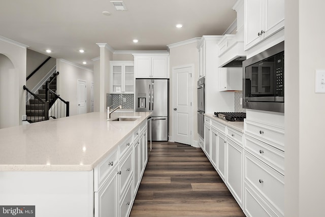 kitchen featuring crown molding, a sink, dark wood-style floors, stainless steel appliances, and white cabinets
