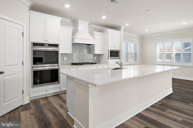kitchen with a sink, stainless steel double oven, premium range hood, gas cooktop, and built in microwave