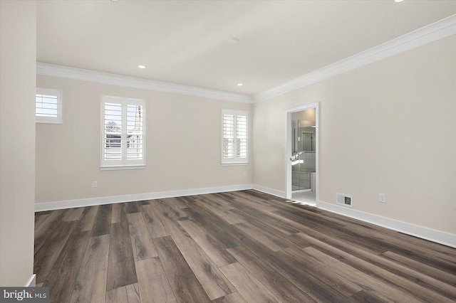 empty room featuring dark wood-style floors, plenty of natural light, and crown molding