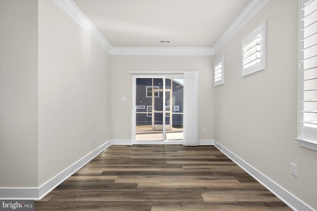 unfurnished room featuring baseboards, visible vents, and ornamental molding