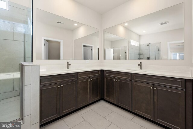 bathroom featuring visible vents, a sink, and a shower stall