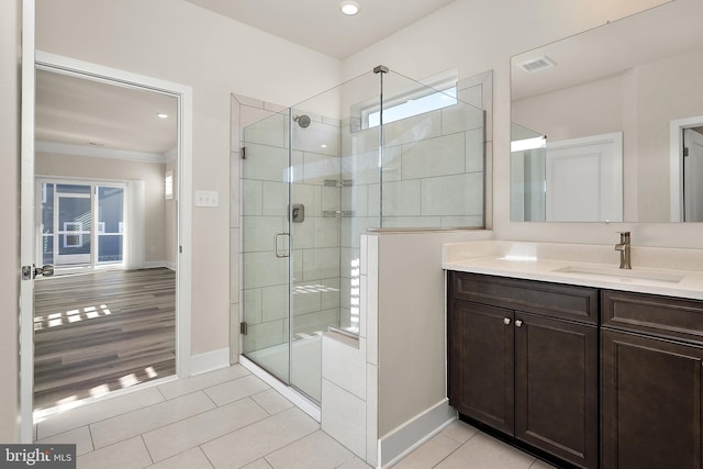 full bathroom featuring baseboards, a stall shower, tile patterned flooring, and vanity