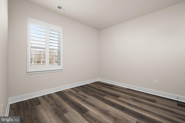 unfurnished room with dark wood-style flooring, baseboards, and visible vents