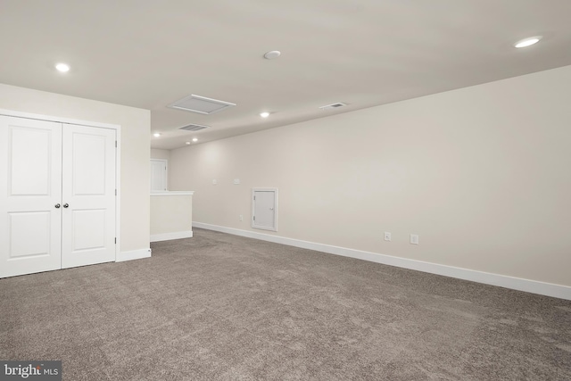 carpeted spare room featuring baseboards, visible vents, recessed lighting, and attic access