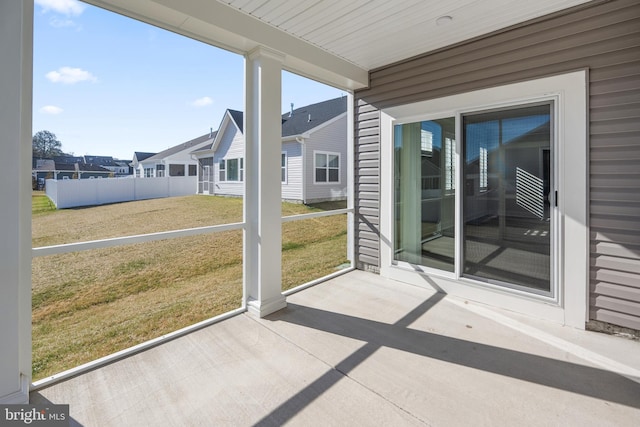 unfurnished sunroom with a residential view and a wealth of natural light