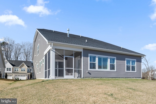 back of house with a sunroom, central AC unit, roof with shingles, and a yard