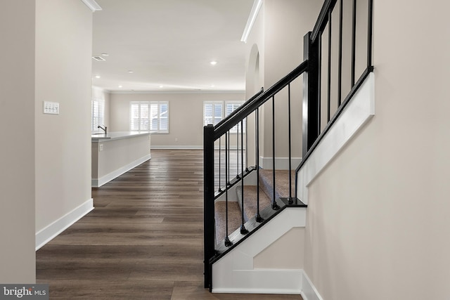 staircase featuring recessed lighting, ornamental molding, baseboards, and wood finished floors
