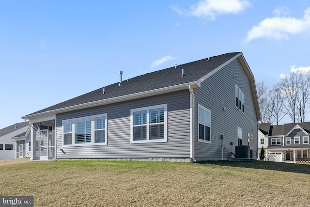 back of house featuring a lawn, a sunroom, and central air condition unit