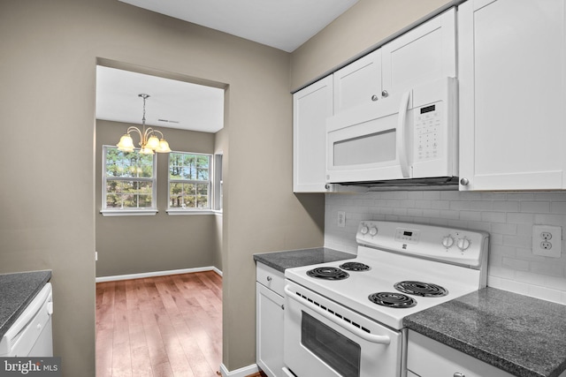 kitchen featuring dark countertops, white appliances, white cabinets, and decorative backsplash