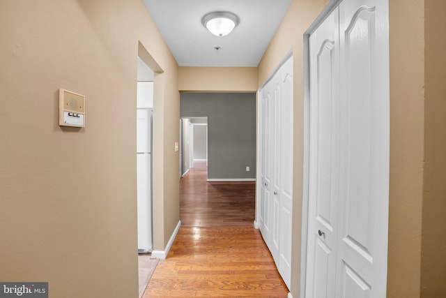 hallway featuring baseboards and wood finished floors