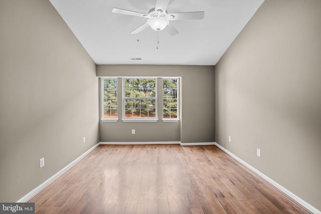 empty room featuring baseboards and light wood finished floors