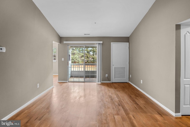 unfurnished room featuring light wood-type flooring, visible vents, and baseboards