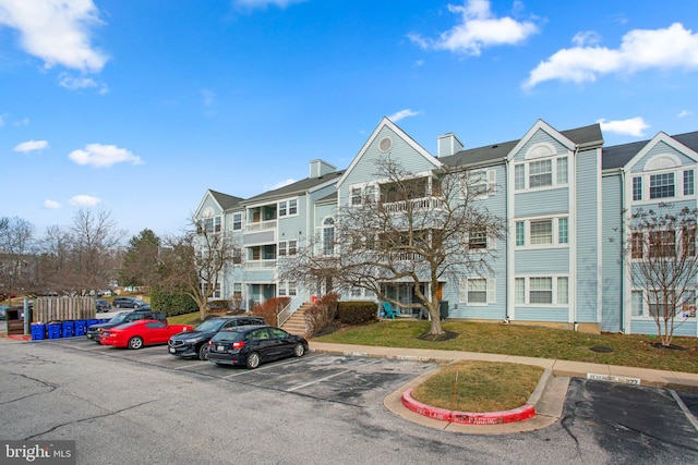 view of property with uncovered parking and a residential view