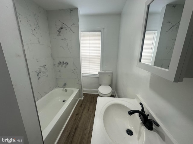 full bathroom with hardwood / wood-style flooring, vanity, toilet, and tiled shower / bath combo