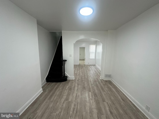 corridor with hardwood / wood-style flooring