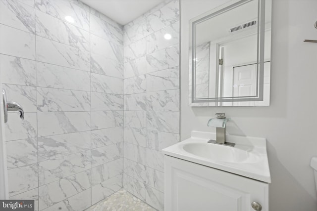 bathroom with vanity and tiled shower