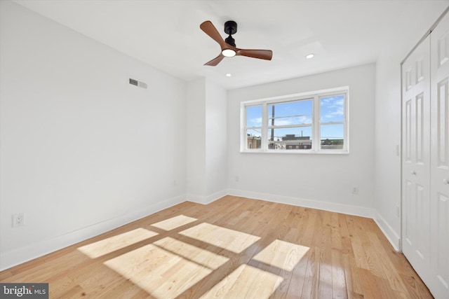 unfurnished bedroom featuring ceiling fan, a closet, and light hardwood / wood-style flooring