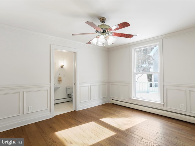 unfurnished room with crown molding, a decorative wall, and a baseboard radiator