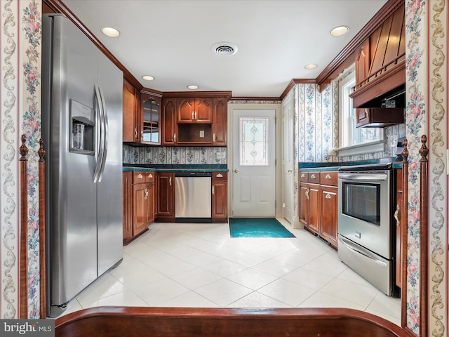 kitchen with dark countertops, light tile patterned floors, appliances with stainless steel finishes, and decorative backsplash
