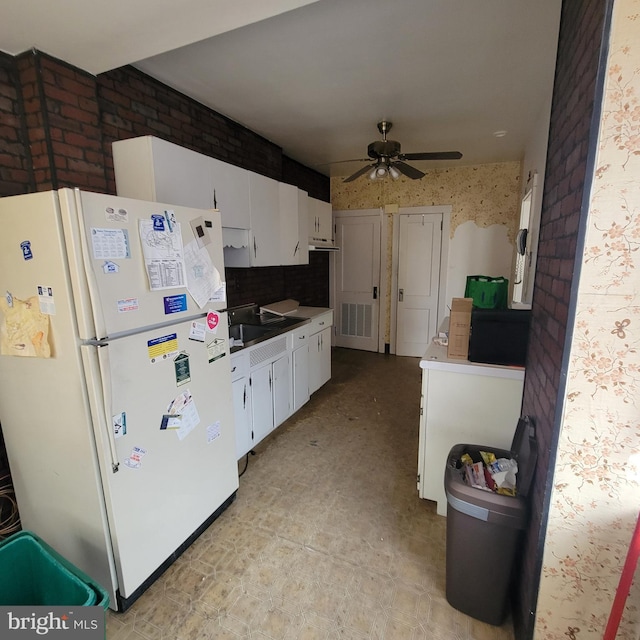 kitchen with white cabinetry, white fridge, sink, and ceiling fan