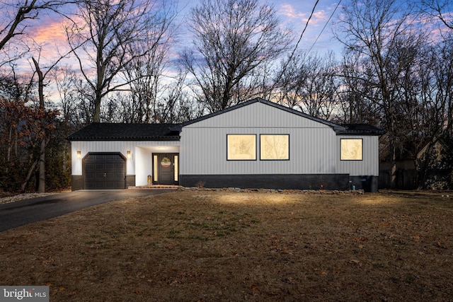 view of front of property with a garage and a yard