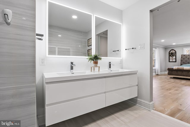 bathroom featuring vanity, wood-type flooring, and ornamental molding