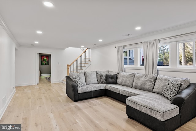 living room with ornamental molding and light wood-type flooring