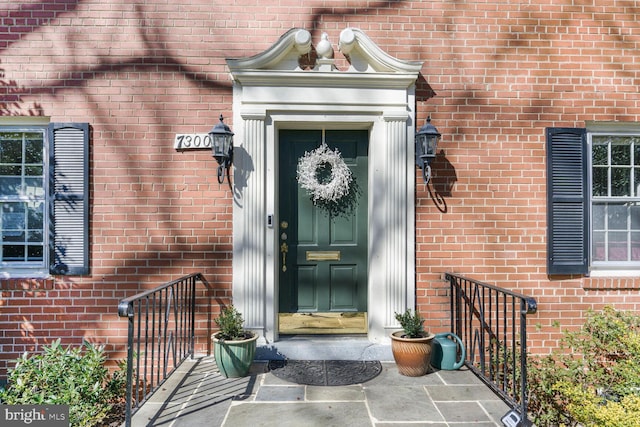 entrance to property featuring brick siding