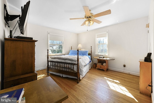 bedroom featuring a ceiling fan, light wood-style flooring, and baseboards